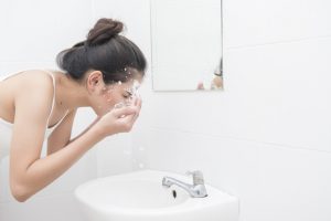 Beautiful asian woman is washing her face